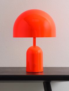 an orange lamp sitting on top of a wooden table