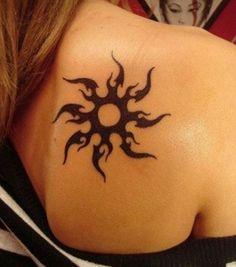 the back of a woman's shoulder with a tattoo design on her left shoulder