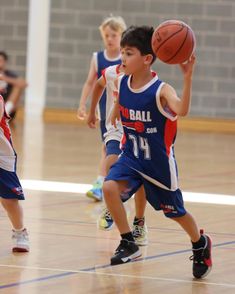 young boys playing basketball on an indoor court