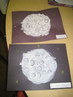 two paper plates are sitting on a table next to each other, with circles and stars painted on them