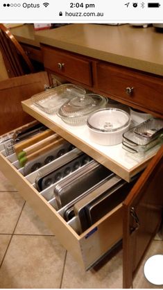 an open drawer in the middle of a kitchen