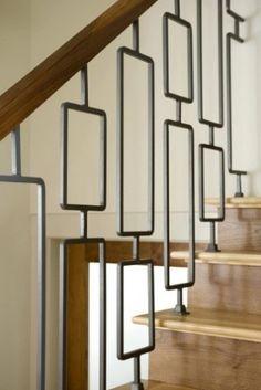 an image of a stair rail with metal bars on it and wood steps in the background