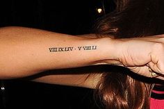 a woman with a tattoo on her arm holding onto another person's arm and the word viviviv written in black ink