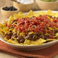 a white plate topped with nachos and salsa