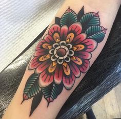 a colorful flower tattoo on the arm