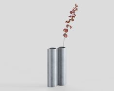 two silver vases with flowers in them sitting side by side on a white surface