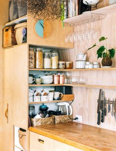 a kitchen with wooden shelves filled with pots and pans