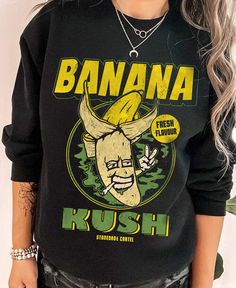 Embrace the quirky and fun with our 'Banana Kush' Unisex Sweatshirt! Made with a 50/50 blend of cotton and polyester, this loose-fitting sweatshirt is not only comfortable but also runs true to size. With a playful original design, you'll be sure to stand out in this unique piece. · Banana Kush Funny Unisex Sweatshirt · 50% Cotton; 50% Polyester · Loose fit · Runs true to size · Original design Printed on Gildan sweatshirts. Care Instructions: Machine wash warm. Non-chlorine: bleach as needed. T Funny Relaxed Fit Sweatshirt For Streetwear, Fun Black Sweatshirt With Graphic Print, Black Letter Print Fun Sweatshirt, Funny Black Graphic Print Sweatshirt, Fun Sweatshirt With Funny Print Relaxed Fit, Relaxed Fit Fun Sweatshirt With Funny Print, Relaxed Fit Funny Print Sweatshirt, Gildan Sweatshirts, 50 50