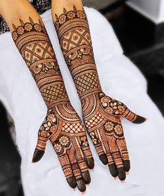 two hands with henna designs on them