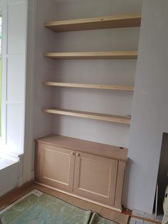 a room with some shelves in it and a rug on the floor next to it