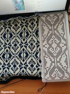 an open laptop computer sitting on top of a wooden desk next to a decorative pillow