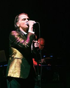 a man in a suit singing into a microphone