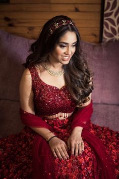 a woman sitting on top of a couch wearing a red dress