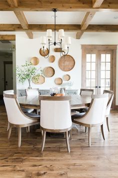 the dining room table is surrounded by white chairs