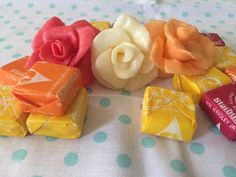 several candy bars with roses on them sitting next to each other in front of a polka dot tablecloth