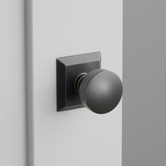 a door knob with a black ball on the front and side of it, against a white wall