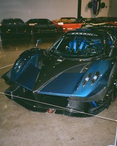 a blue and black sports car parked in a garage