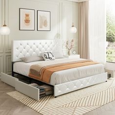 a white bed sitting on top of a hard wood floor next to a large window