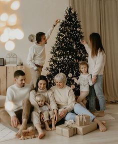 a family sitting in front of a christmas tree