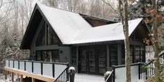 a small cabin in the woods with snow on the ground and stairs leading up to it