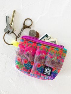 a small purse with keys and money in it