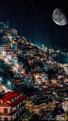 the full moon shines brightly in the night sky over a city with many buildings