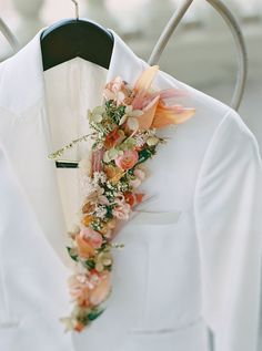 a white suit with flowers on the lapel