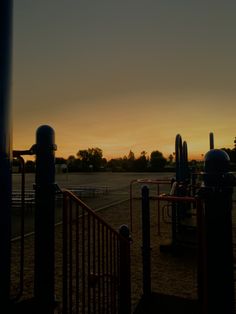 the sun is setting over an empty playground