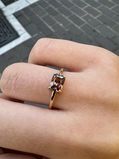 a woman's hand with a ring on it that has a brown and white diamond in it