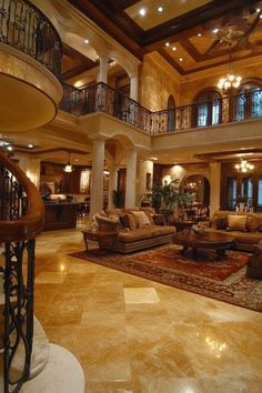 a large living room with high ceilings and chandeliers on the second floor is shown