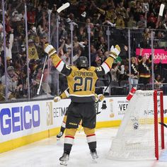 the hockey player is celebrating his goalie's win in front of an audience