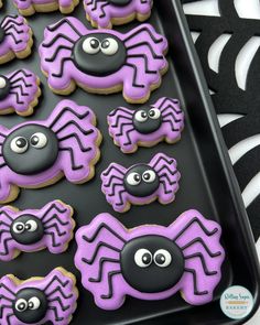 purple and black decorated cookies with googly eyes in the shape of spider's