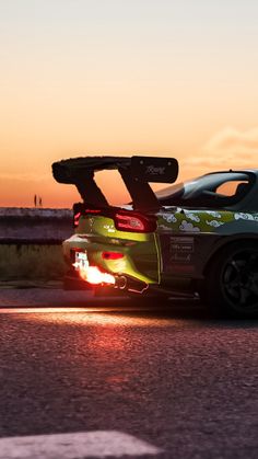 a car driving down the road at sunset