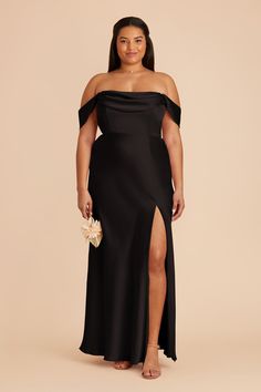 a woman wearing a black dress with an off the shoulder slit