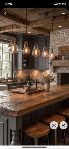 an image of a kitchen with lights hanging from the ceiling and stools on the counter