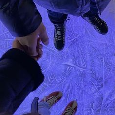 two people standing next to each other with their feet on the ground and holding hands