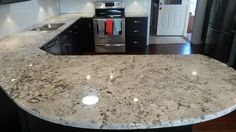 a kitchen with an island in the middle of it and black cabinets on both sides