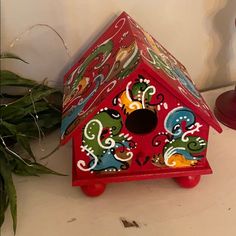 a red birdhouse sitting on top of a table