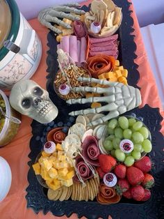 a table topped with plates and bowls filled with different types of food next to a skull