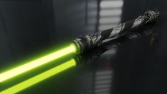 a green light saber is glowing in the dark