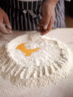 a person in an apron is kneading flour on a table