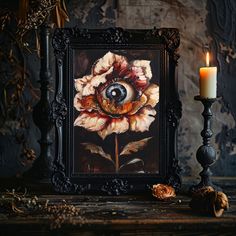 an eyeball in the middle of a painting next to a candle and some flowers