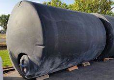 a large black tank sitting on the side of a road