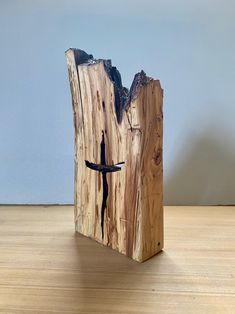 a piece of wood that has been carved to look like a tree stump with a bird on it