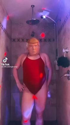 a man in a red swimsuit standing in a shower stall with his hands on his hips