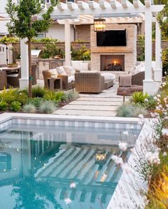 an outdoor living area with couches, chairs and a fire place next to a swimming pool