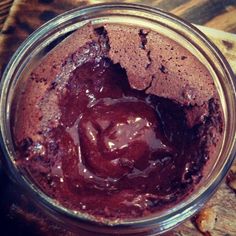 a glass jar filled with chocolate pudding on top of a wooden table