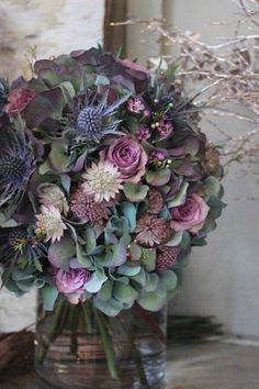 a vase filled with lots of purple flowers