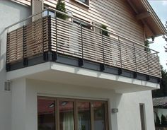 a balcony with wooden slats on the side of a building