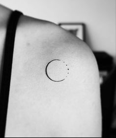 a black and white photo of a crescent tattoo on the back of a woman's shoulder